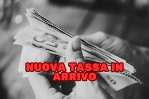 mani che contano banconote euro da 50 in bianco e nero e scritta rossa "nuova tassa in arrivo"