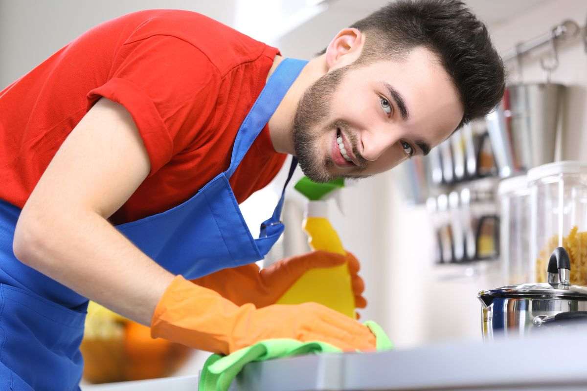 Uomo lava bene il piano cottura