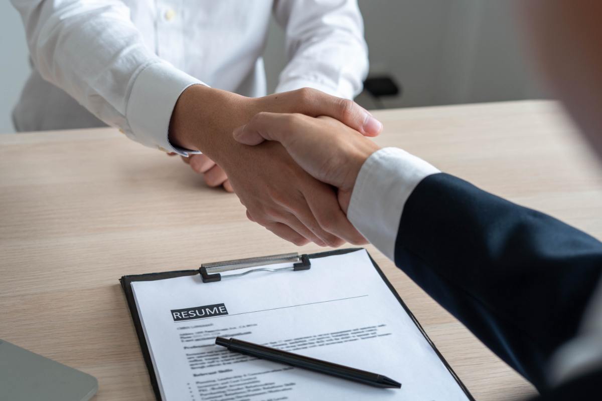 persone che si stringono la mano davanti a un contratto