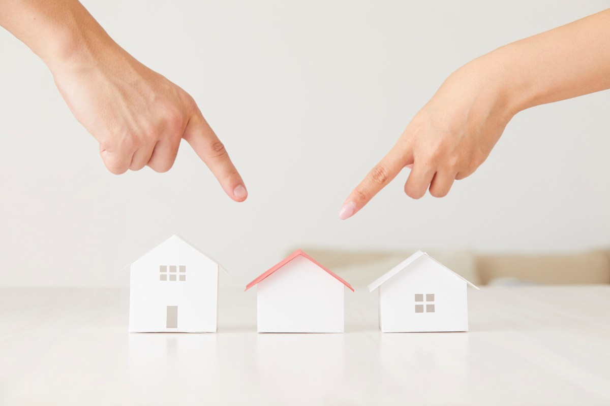 mani che indicano modellini casette