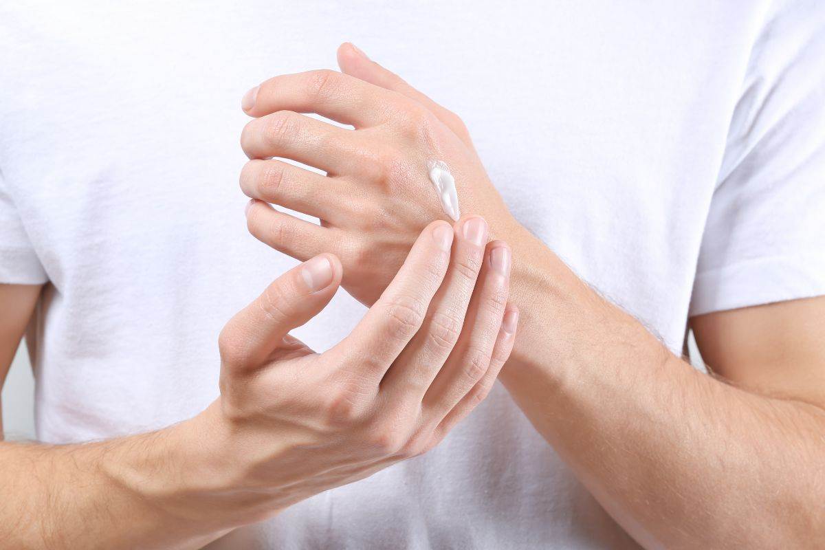 Ragazzo applica crema idratante sulle mani