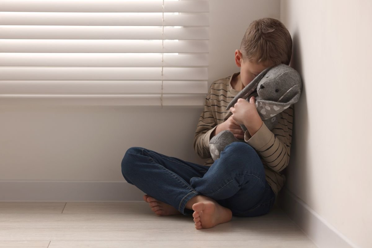 Bimbo seduto in un angolo