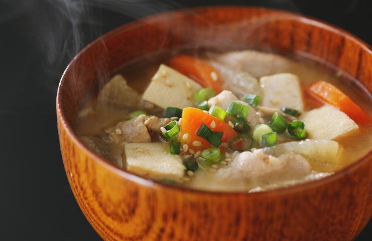 Brodo caldo in ciotola di legno