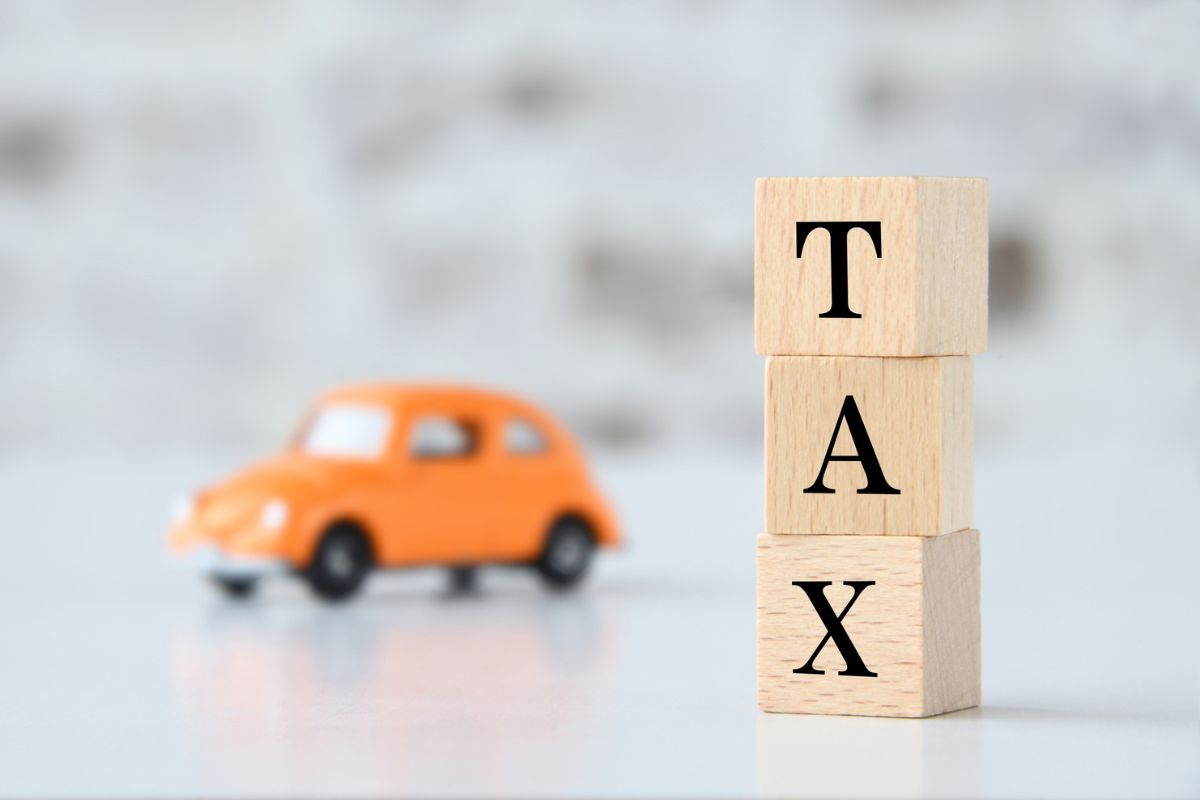 macchinina arancione con quadrati di legno che formano la parola tax