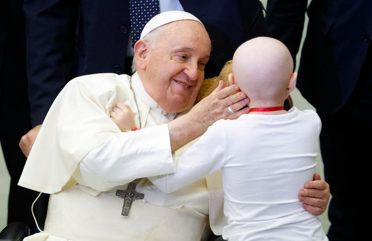 Papa Francesco accarezza un bambino sulla guancia
