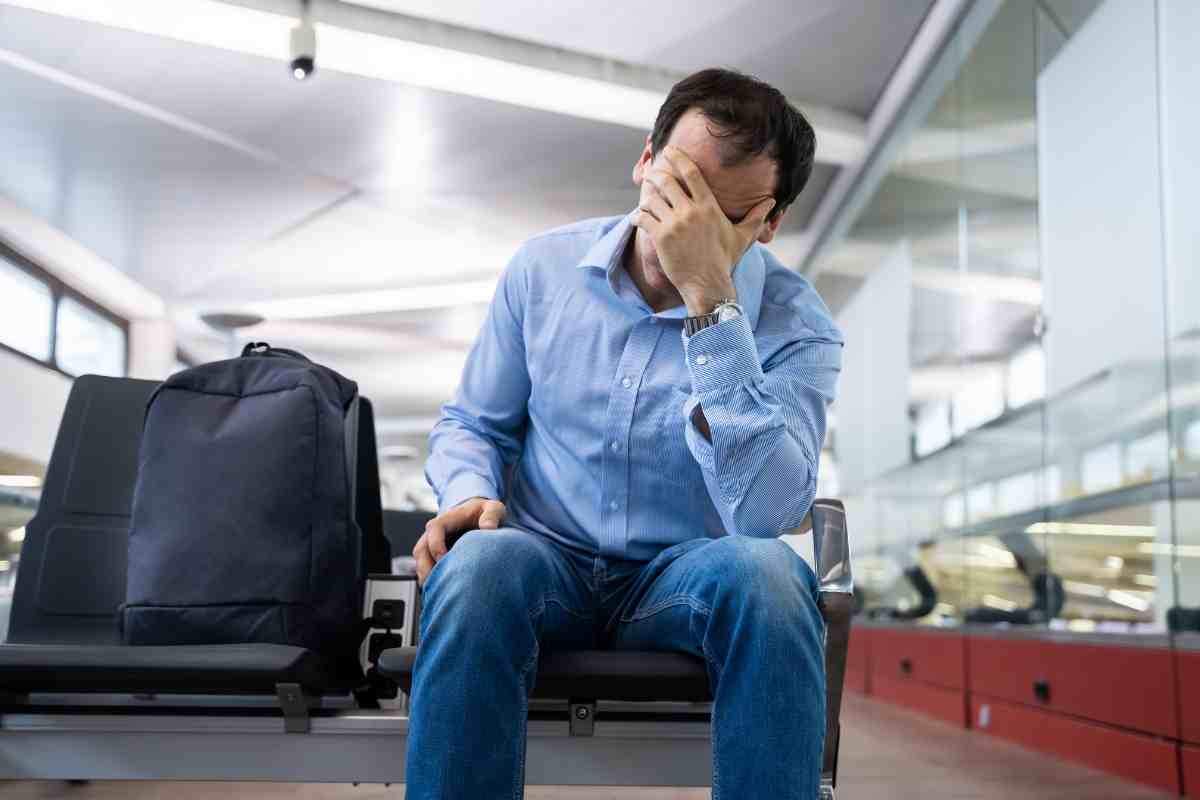 Persona si tocca la fronte con la mano