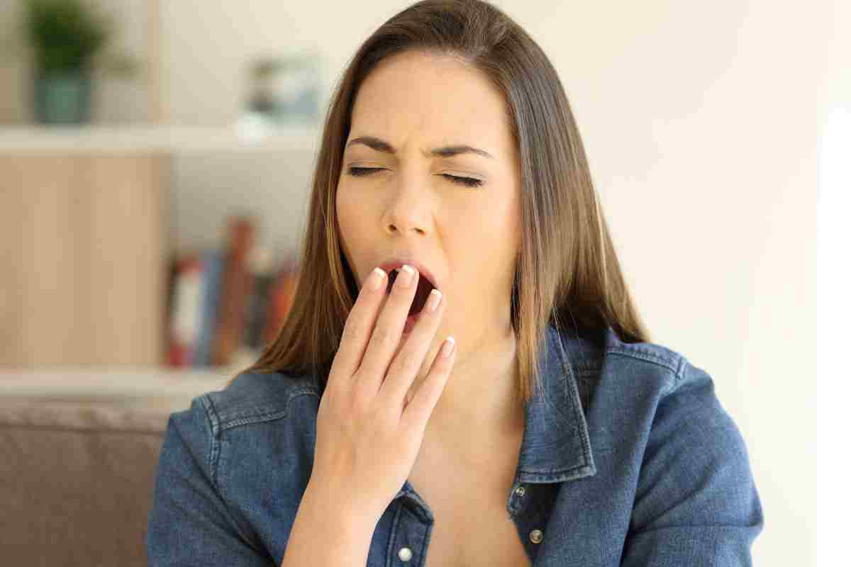 giovane donna sbadiglia per sonno