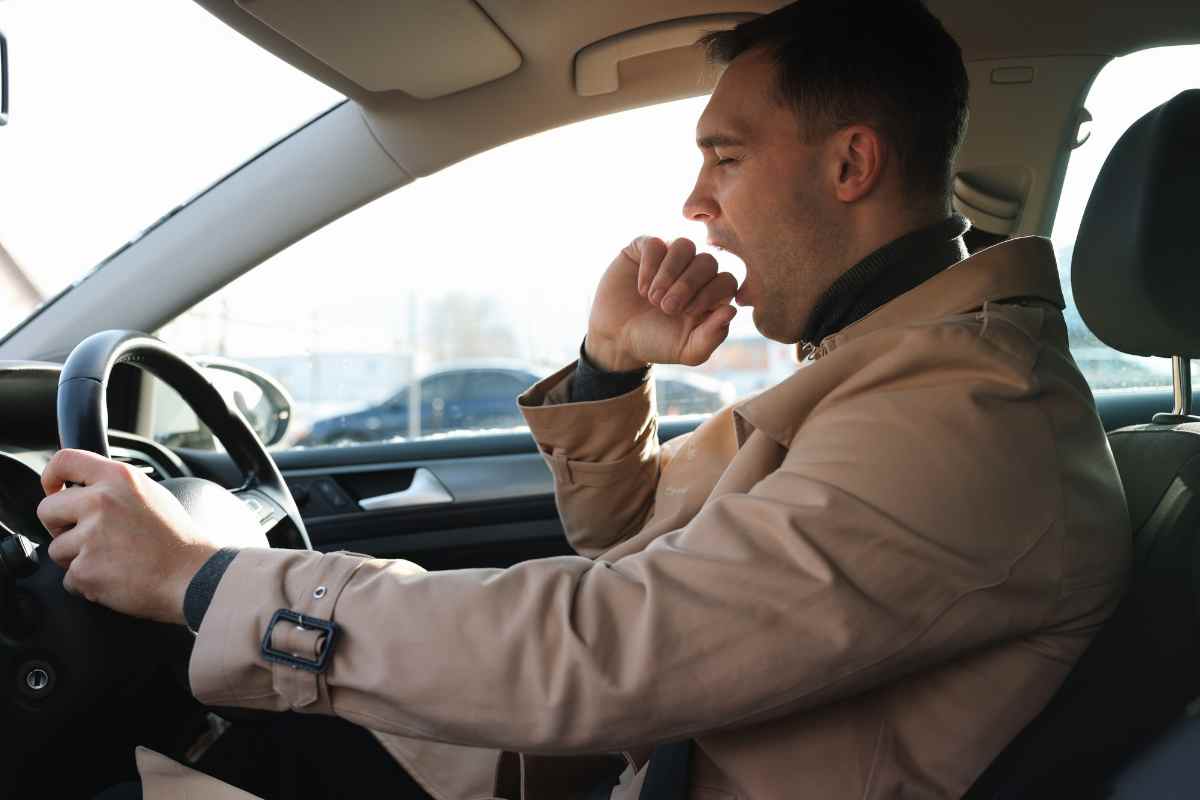 Uomo sbadiglia in auto