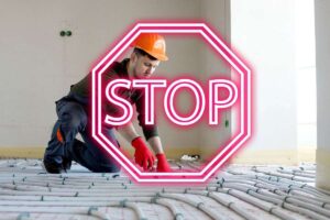 tecnico installa riscaldamento a pavimento scritta stop in evidenza