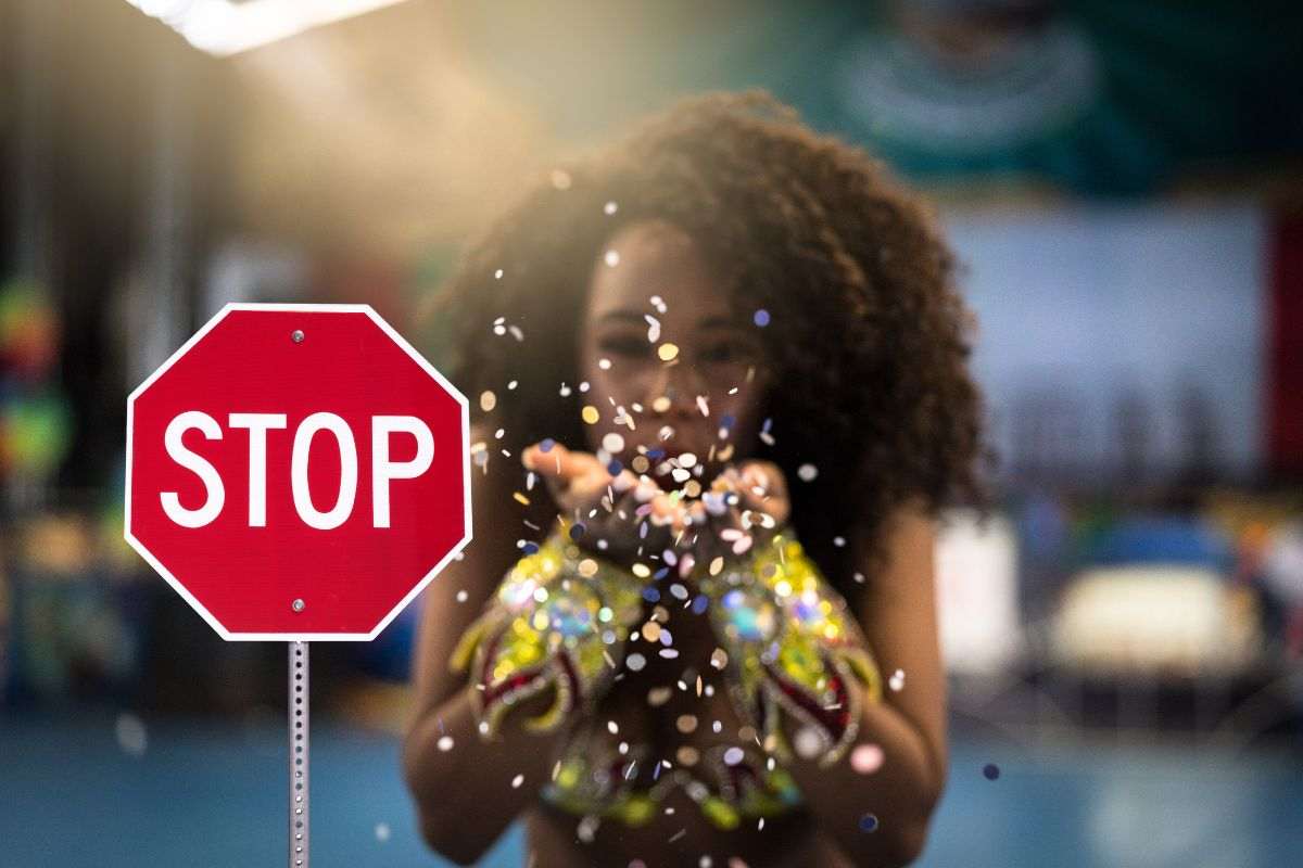 segnale di stop e donna che soffia coriandoli