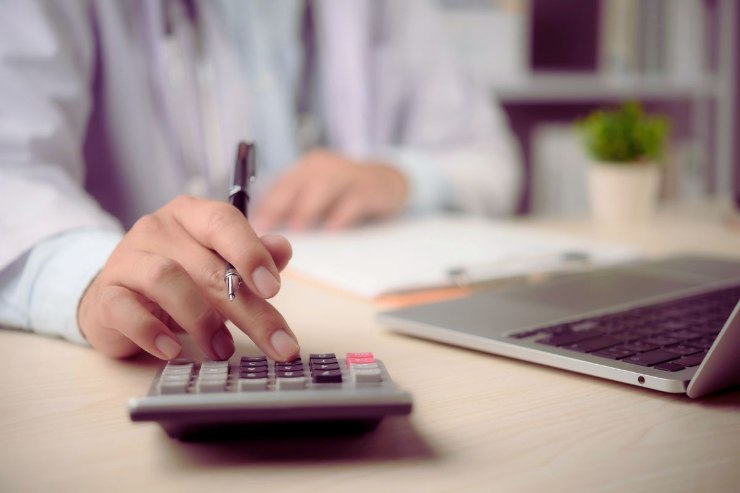 uomo fa conti con calcolatrice