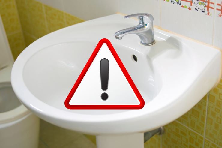 lavandino domestico e segnale di pericolo