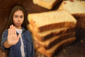 fette biscottate su superficie di legno e donna seria che fa stop con le mani