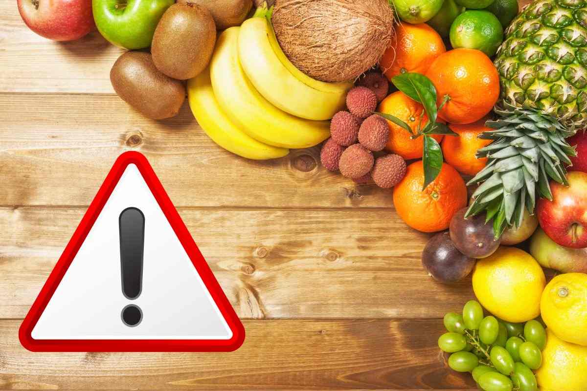 frutta assortita e segnale di pericolo in evidenza