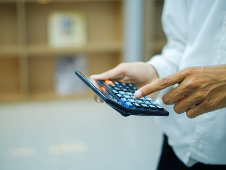 uomo con calcolatrice in mano 