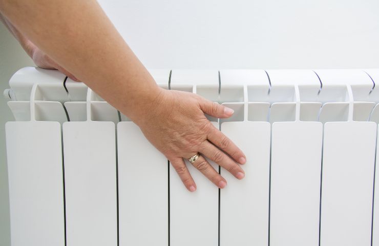 mano di donna che tocca termosifoni 