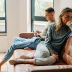 coppia seduta sul divano con la donna che da le spalle all'uomo