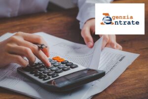 donna fa conti con calcolatrice e logo agenzia delle entrate