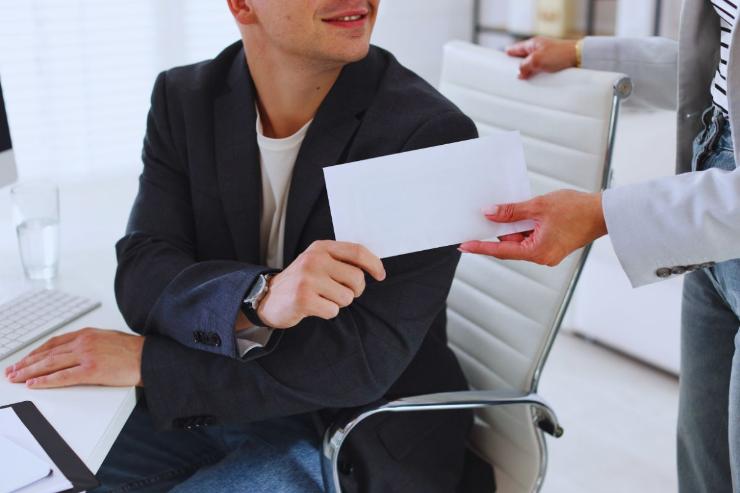 uomo consegna una busta ad un altro